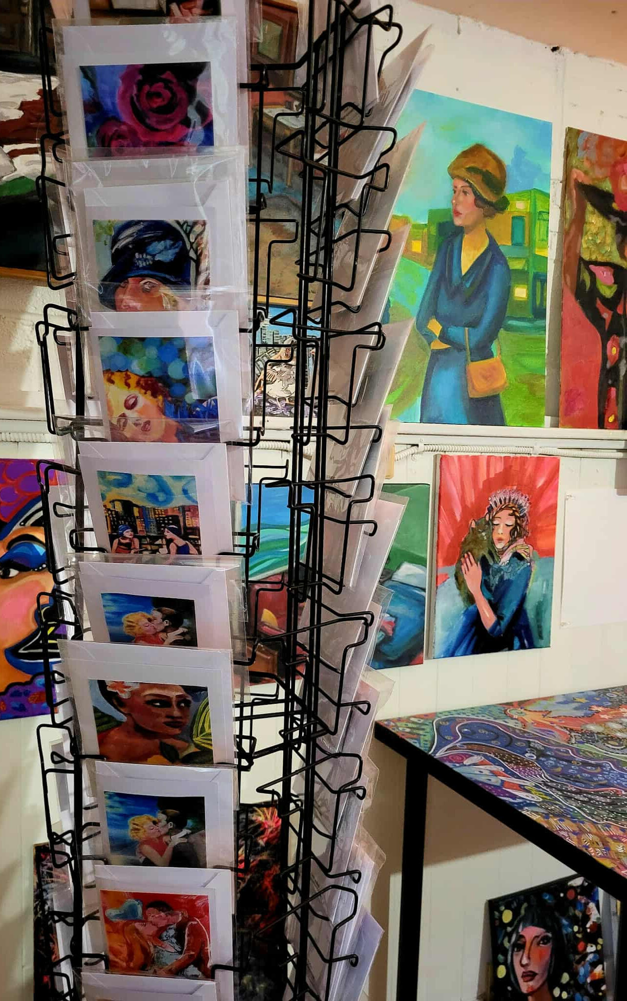 photo by Lucie Walker photof of a ceramic crow, a ceramic plate of gemstones, a lit salt lamp, a fern, some hanging ornaments in a window